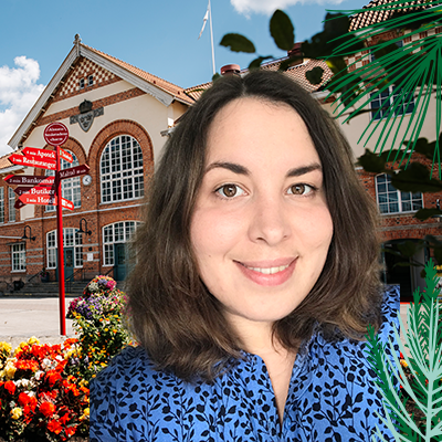 Porträttbild på Lovisa Neiktar, samhällsplanerare på Alvesta kommun, med Alvesta stationshus i bakgrunden.