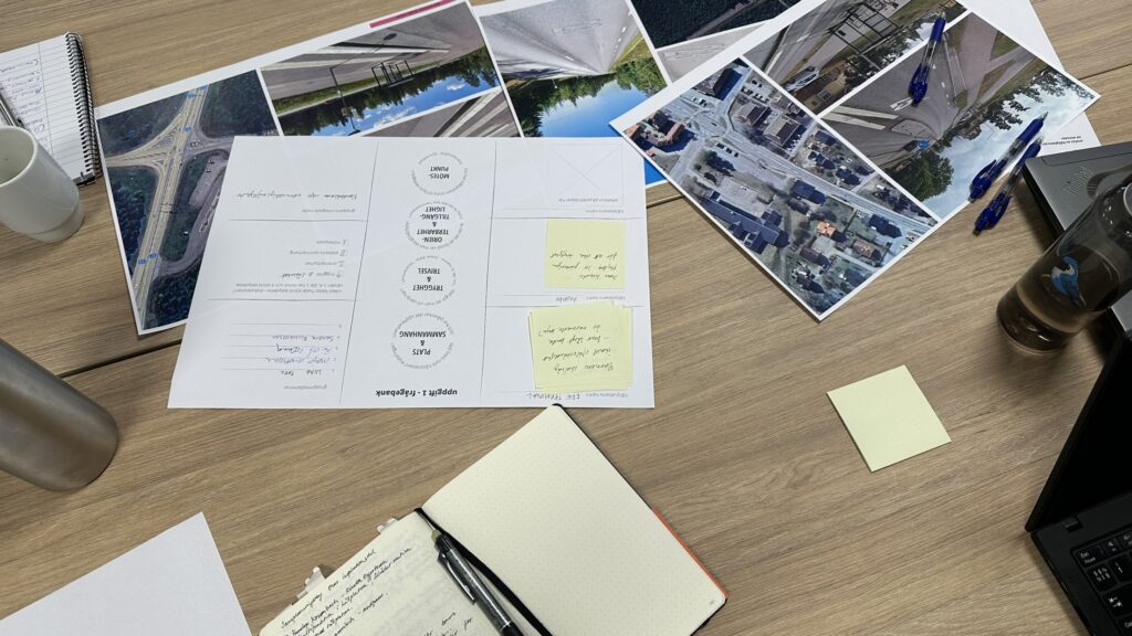 Kartor, foton och anteckningar på ett bord under analysarbete.